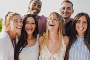 Group of adults smiling after impacted wisdom tooth extraction