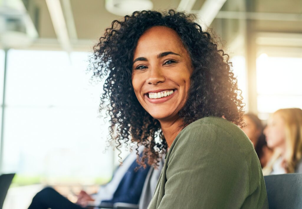 a smiling woman who has already undergone wisdom tooth removal as well as a smooth recovery thanks to South Calgary Oral Surgery