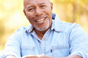 senior male smiling big showing off his new natural looking dentures